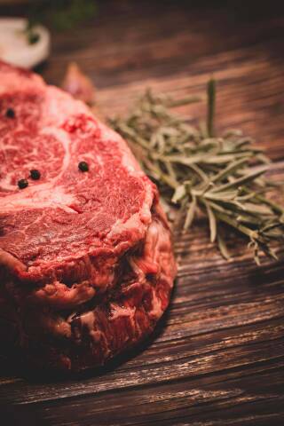 Meztgerei/Wursterei Gebrüder Felder Safenwil mit einem Bild von einem rohen Steak mit Rosmarinzweig